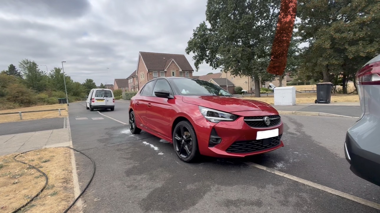 Red car freshly valeted on a residential street